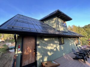 Mountain home featuring a standing seam metal roof with snow retention system, seamless gutters, and custom metal detailing.